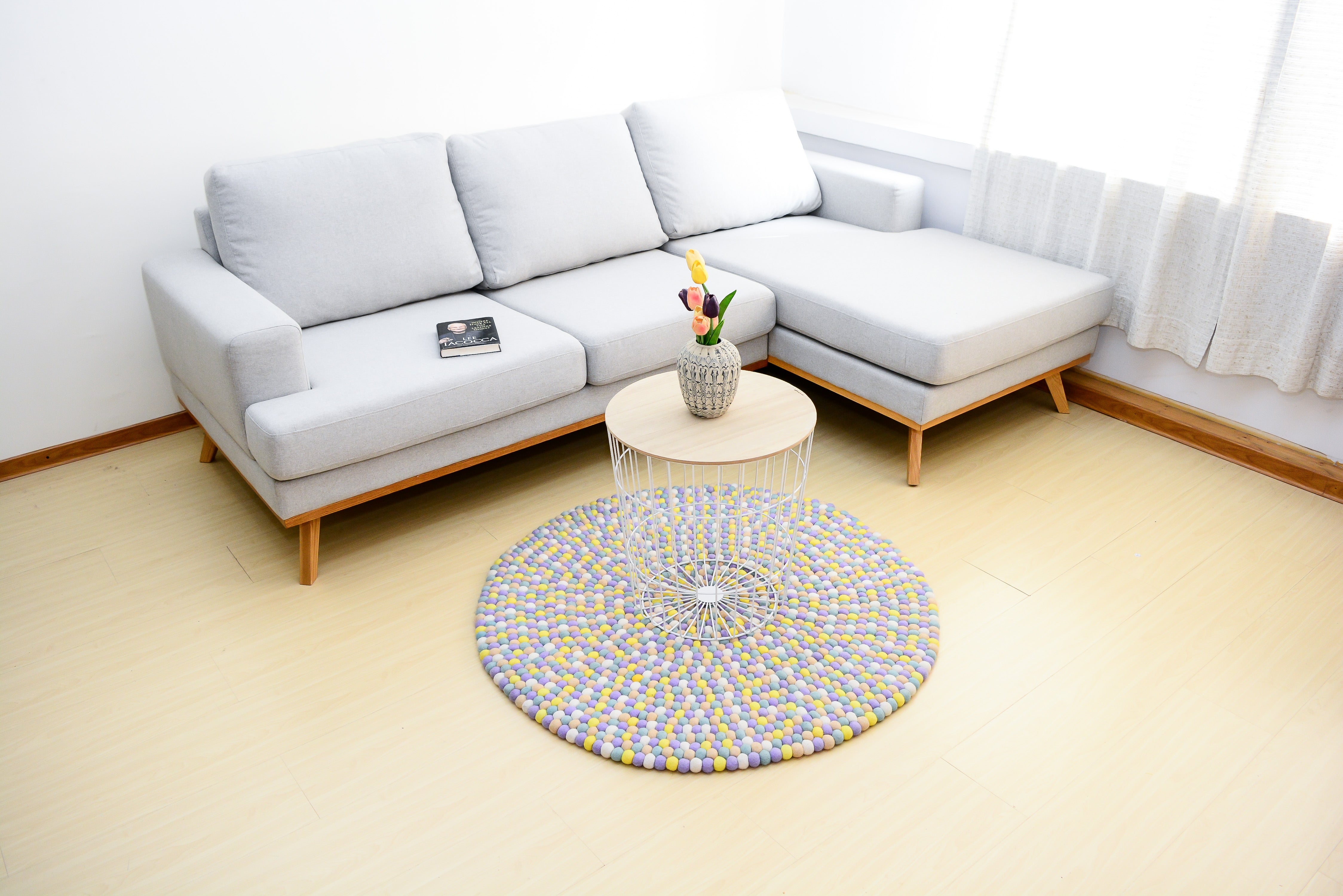 Tapis rond artisanal en feutre de laine à boules pastel