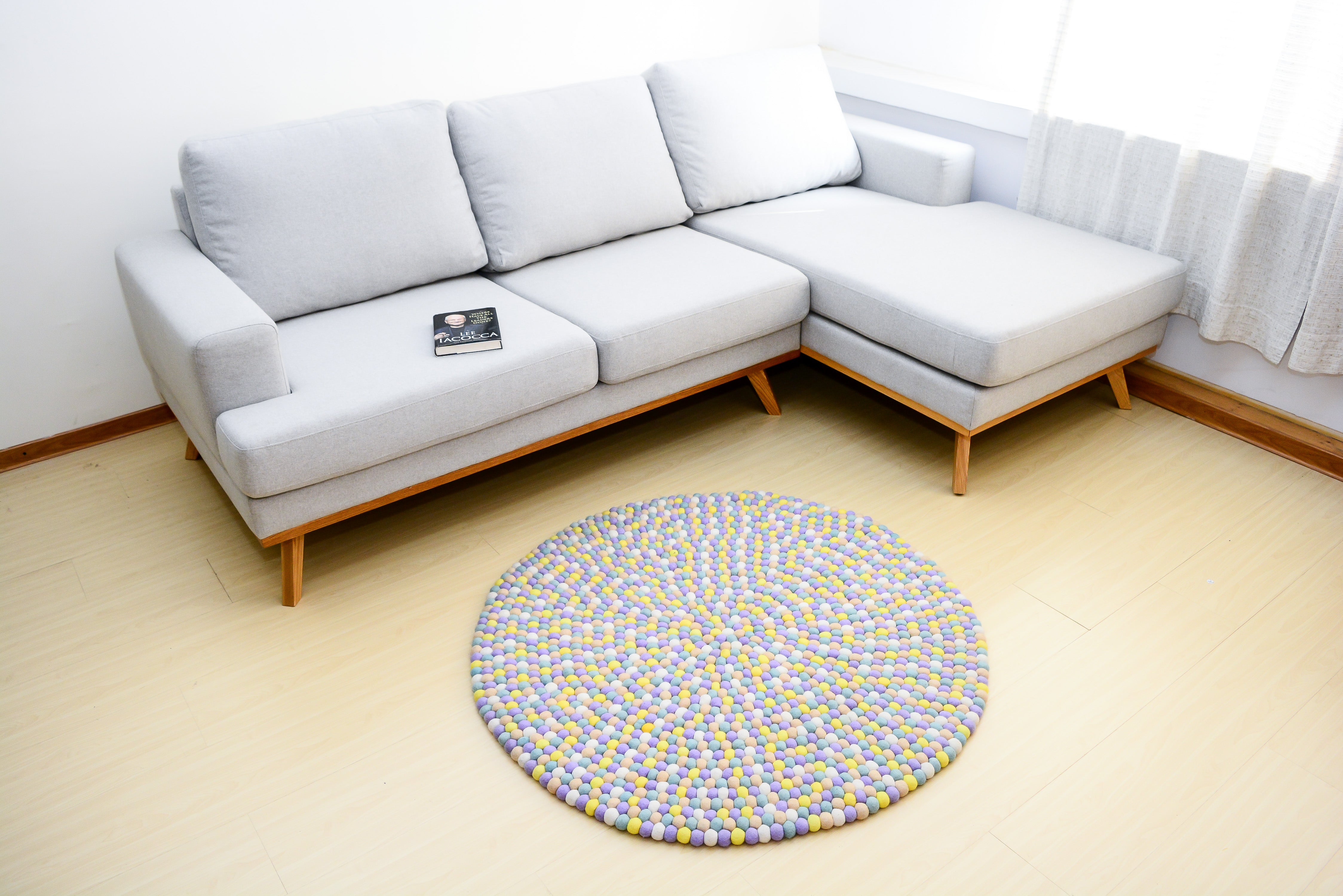 Tapis rond artisanal en feutre de laine à boules pastel