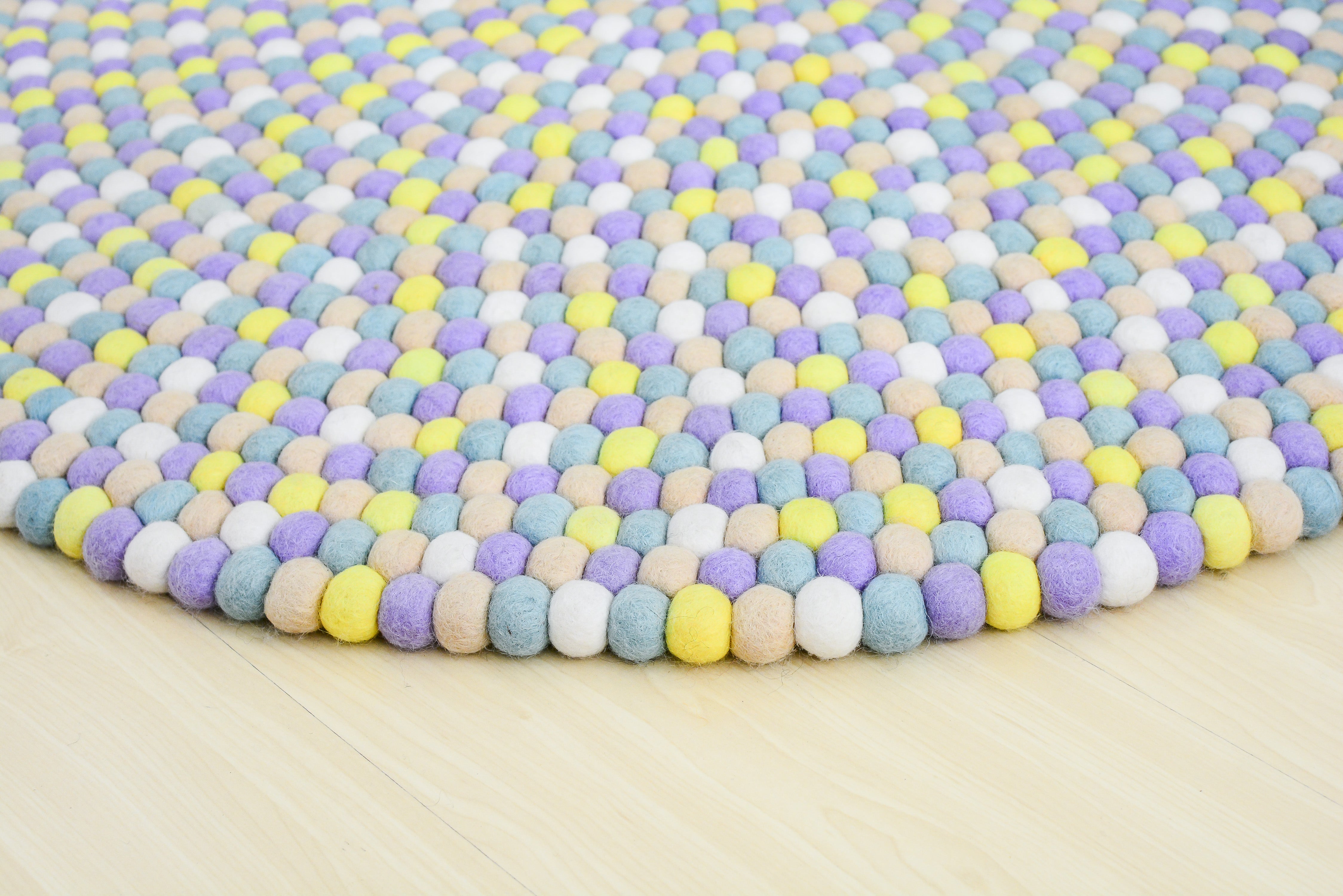 Tapis rond artisanal en feutre de laine à boules pastel