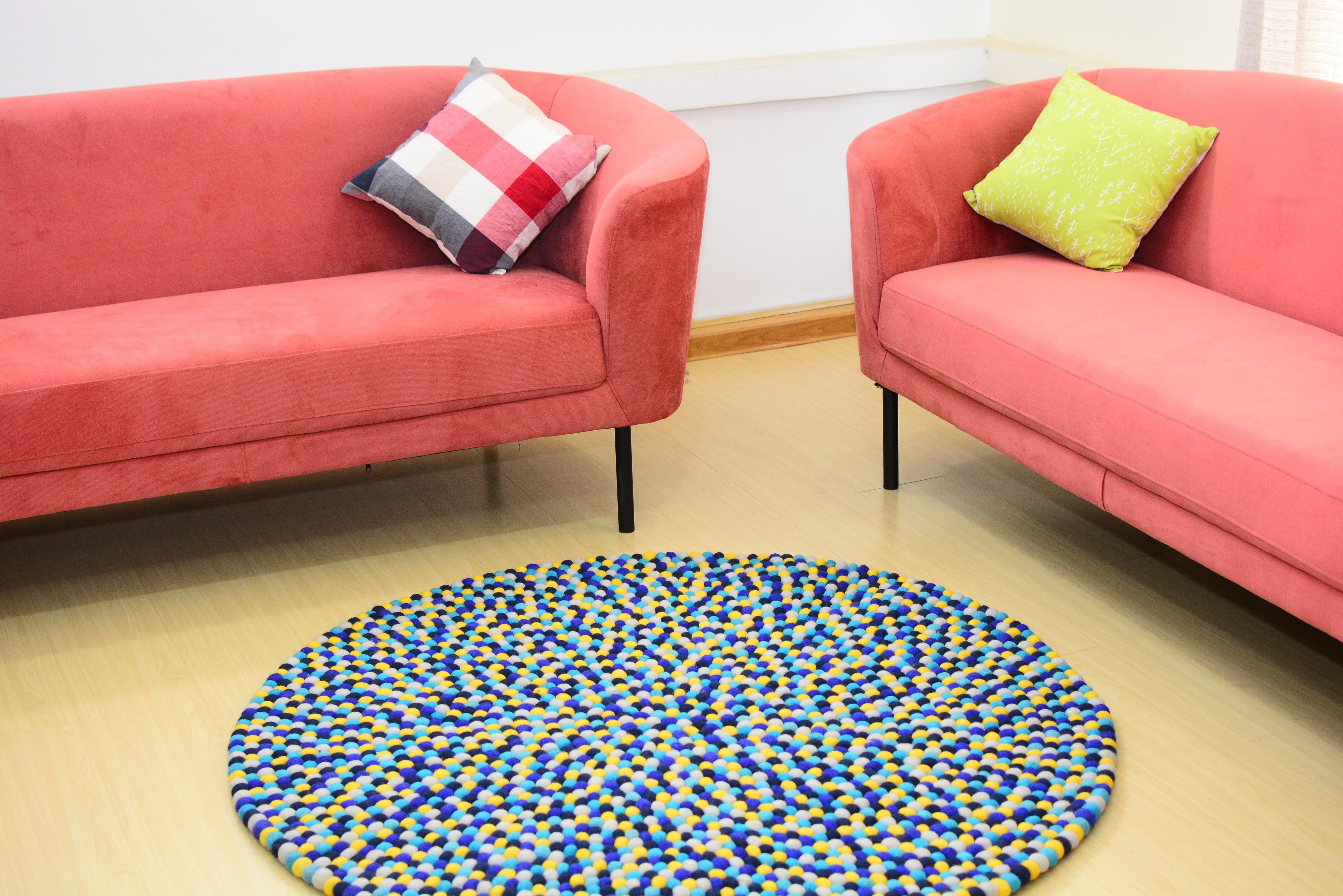 Tapis rond artisanal en feutre de laine à boules bleu et jaune