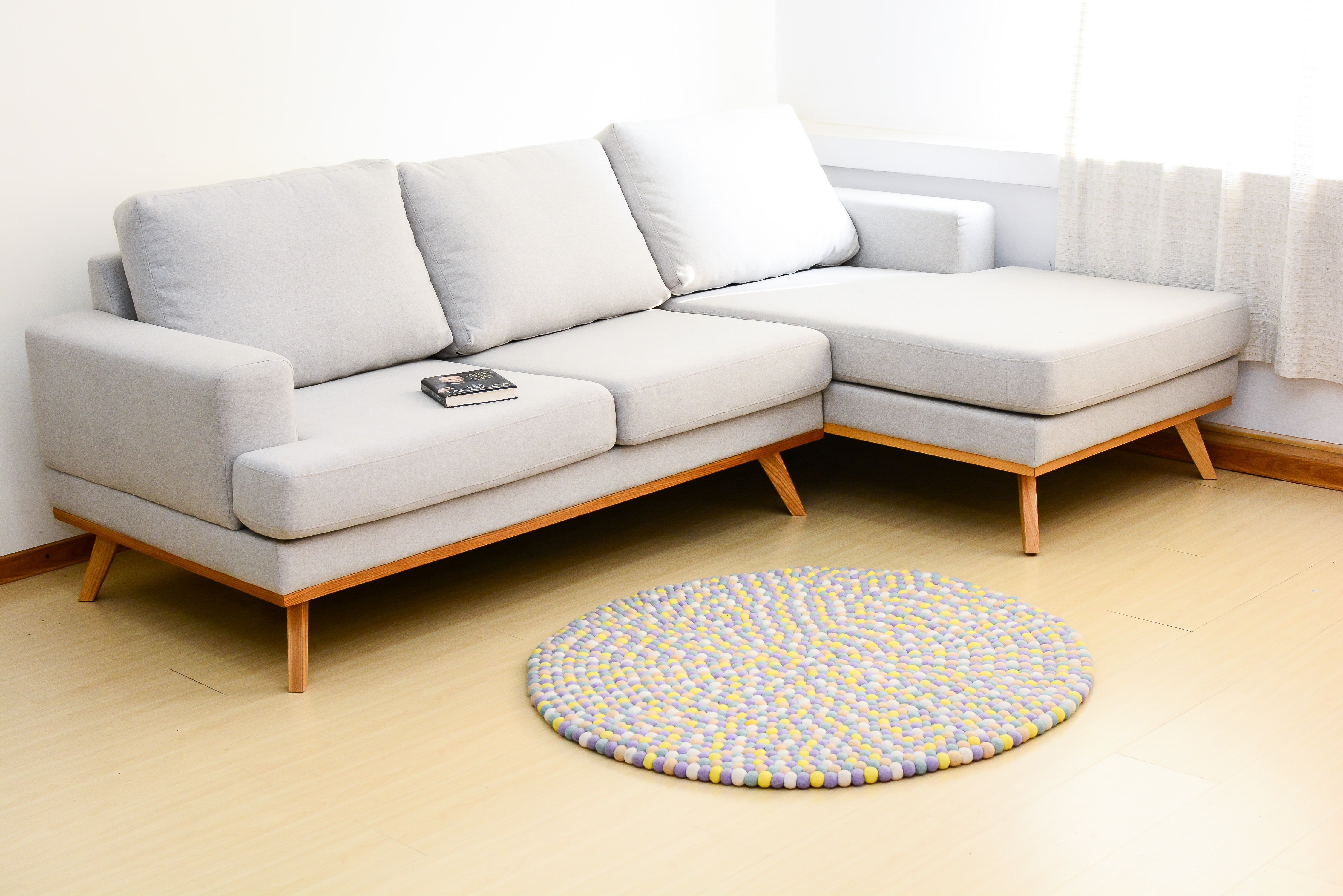Tapis rond artisanal en feutre de laine à boules pastel