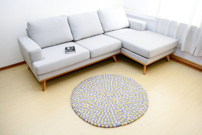 Tapis rond artisanal en feutre de laine à boules pastel