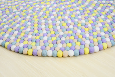 Tapis rond artisanal en feutre de laine à boules pastel
