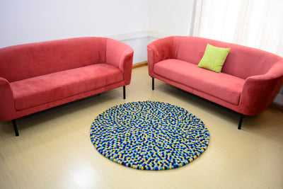 Tapis rond artisanal en feutre de laine à boules bleu et jaune