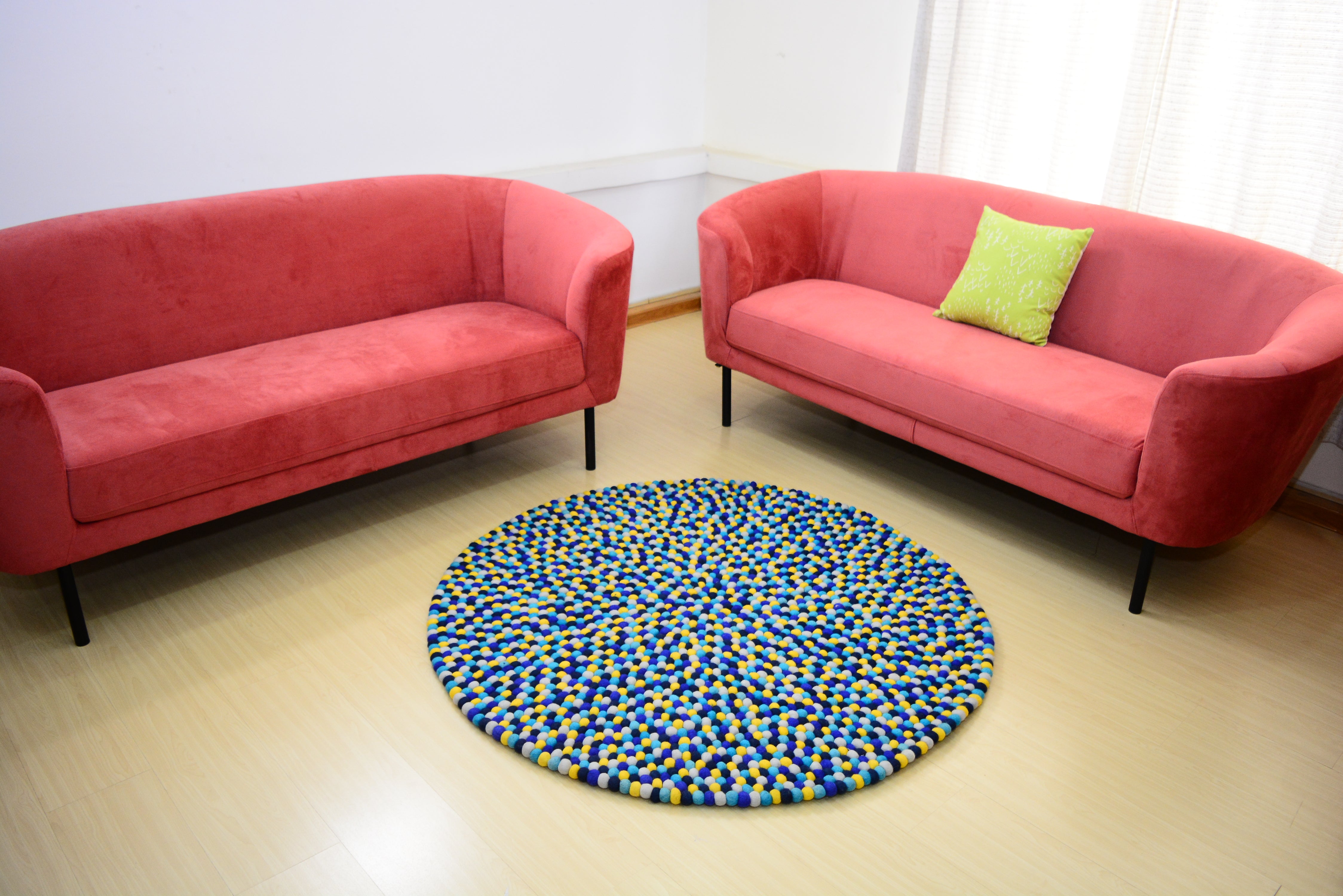 Tapis rond artisanal en feutre de laine à boules bleu et jaune