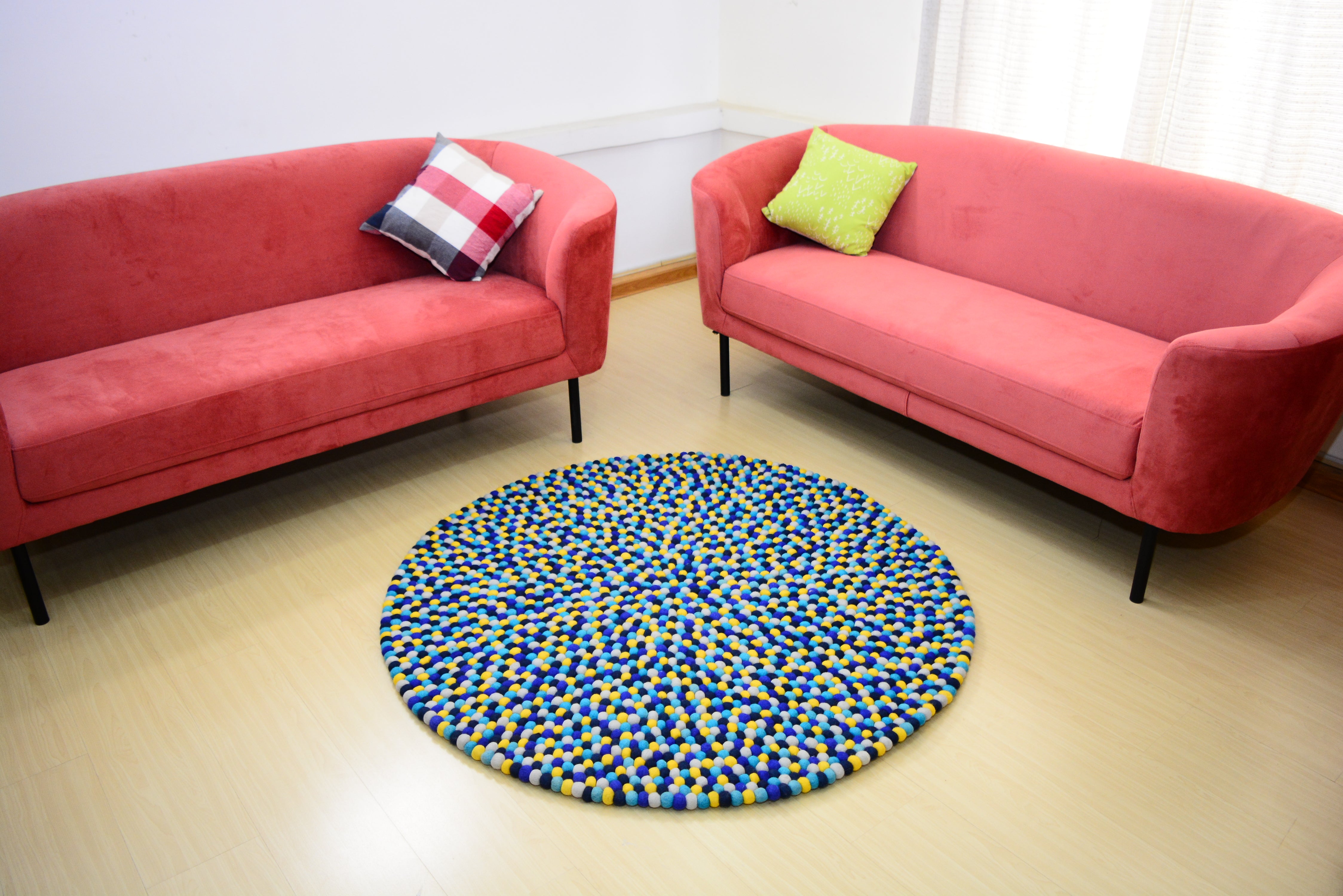 Tapis rond artisanal en feutre de laine à boules bleu et jaune