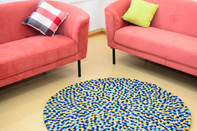 Tapis rond artisanal en feutre de laine à boules bleu et jaune