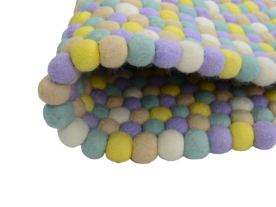 Tapis rond artisanal en feutre de laine à boules pastel
