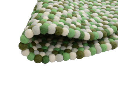 Tappeto rotondo in feltro e lana, realizzato a mano, nei toni del verde.