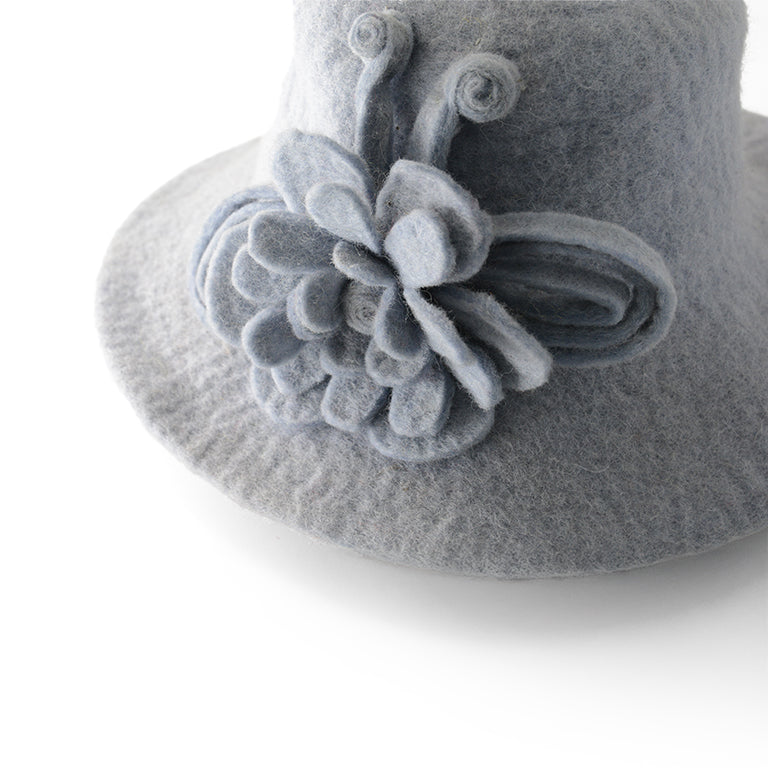 Incantevole cappello in feltro di lana grigio con decorazione floreale.